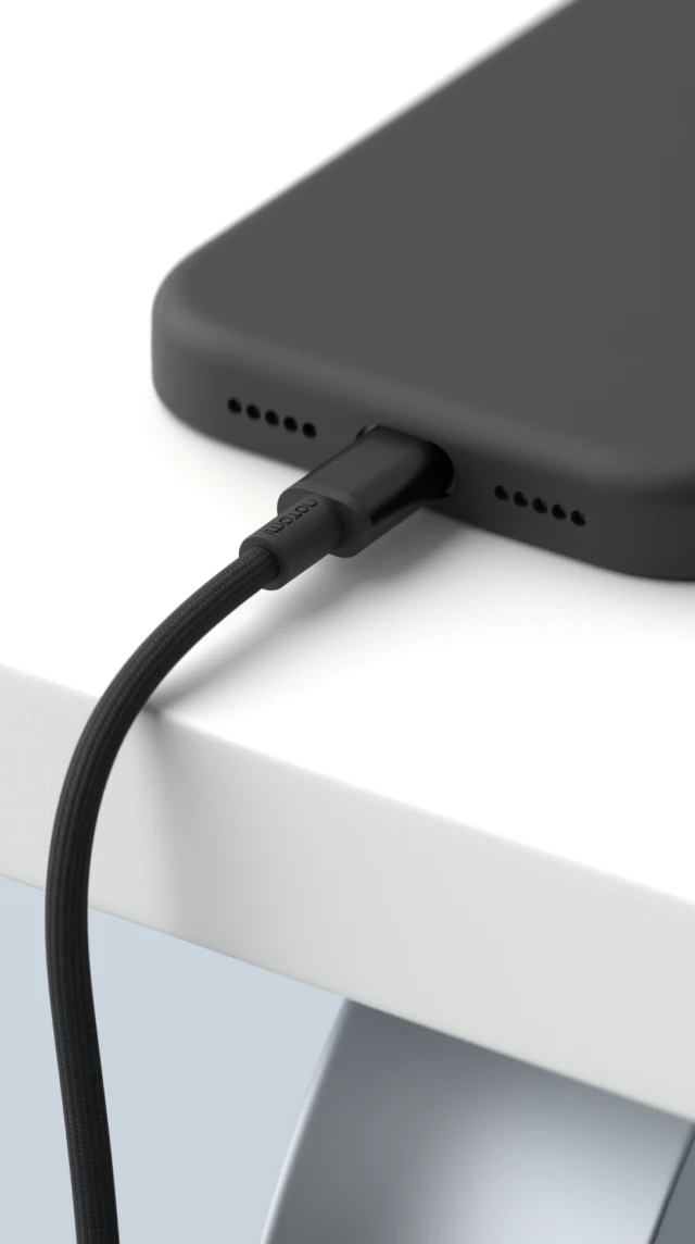 Smartfon podłączony do ładowania białym kablem magnetycznym USB-C do USB-C Notomi 100 W na krawędzi biurka.
