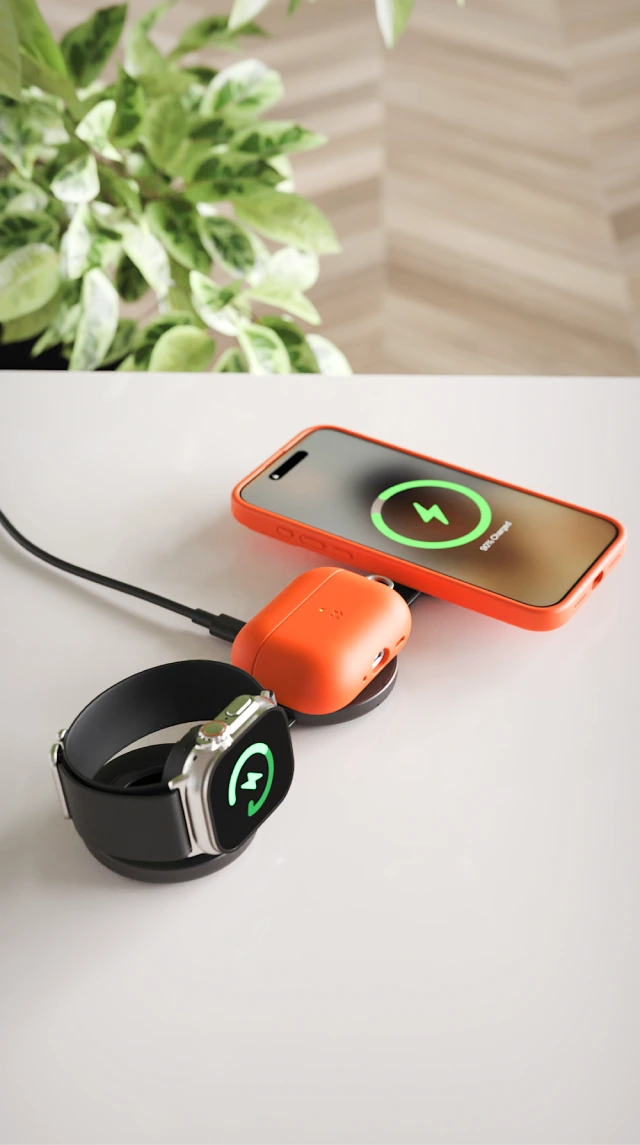 Składana biała mini ładowarka indukcyjna Noto Charge Pad Go pokazana na stole, podczas ładowania Apple Watch, Air Pods Pro 3 i iPhone 17 Pro.