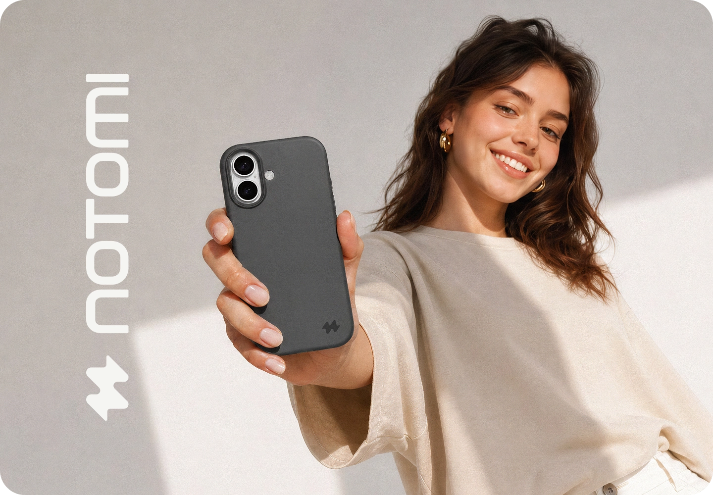 Kobieta trzyma iPhone 18 Pro Max w pomarańczowym etui silikonowym MagSafe Notomi, prezentując minimalistyczne wykończenie, dopasowanie do telefonu i elegancki design akcesorium.