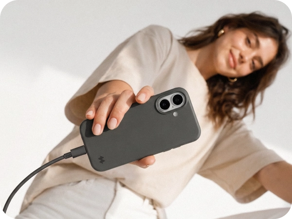 Kobieta prezentuje iPhone 18 Pro Max w pomarańczowym etui silikonowym MagSafe Notomi z podłączonym przewodem ładowania, pokazując dopasowanie etui i wygodny dostęp do portu USB-C.