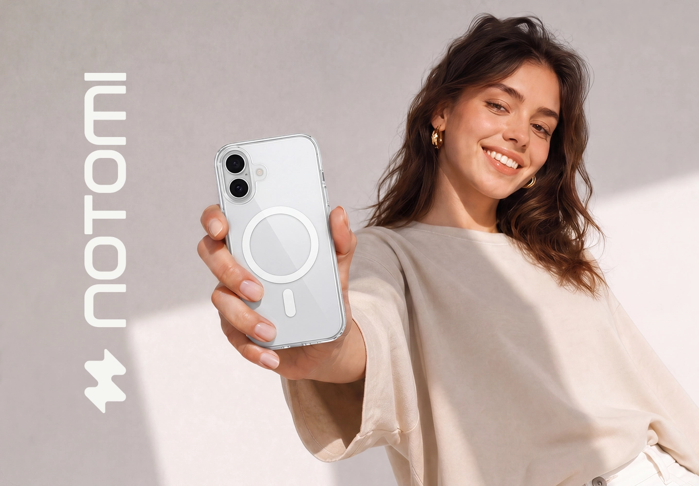 Młoda kobieta trzyma iPhone 15 w transparentnym etui Clear MagSafe Notomi, prezentując minimalistyczne wykończenie, dopasowanie do telefonu i elegancki design akcesorium.