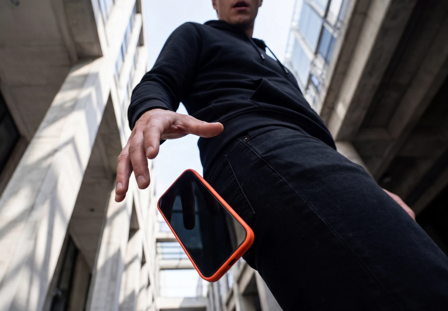 Mężczyzna upuszcza smartfon ze szkłem hartowanym Notomi 9H, pokazując ochronę ekranu przed uderzeniami.