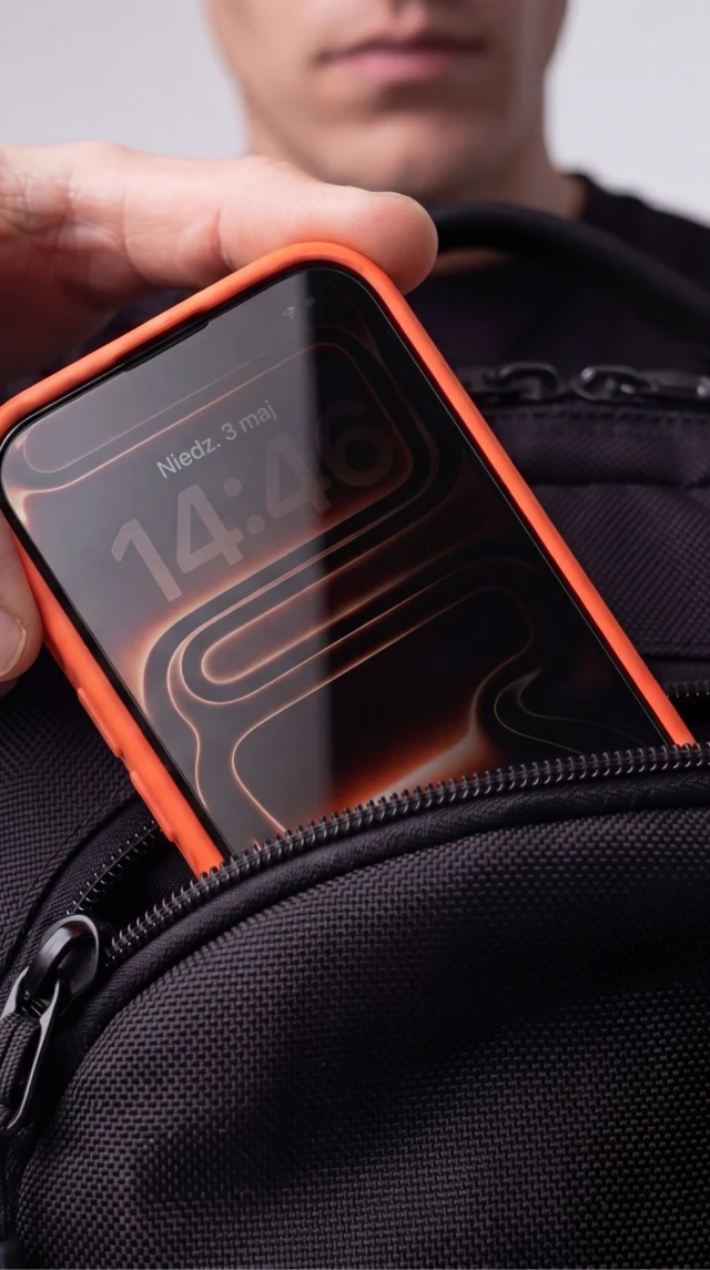 Mężczyzna wkłada iPhone z prywatyzującym szkłem hartowanym Notomi 9H do torby, pokazując ochronę ekranu przed zarysowaniami.