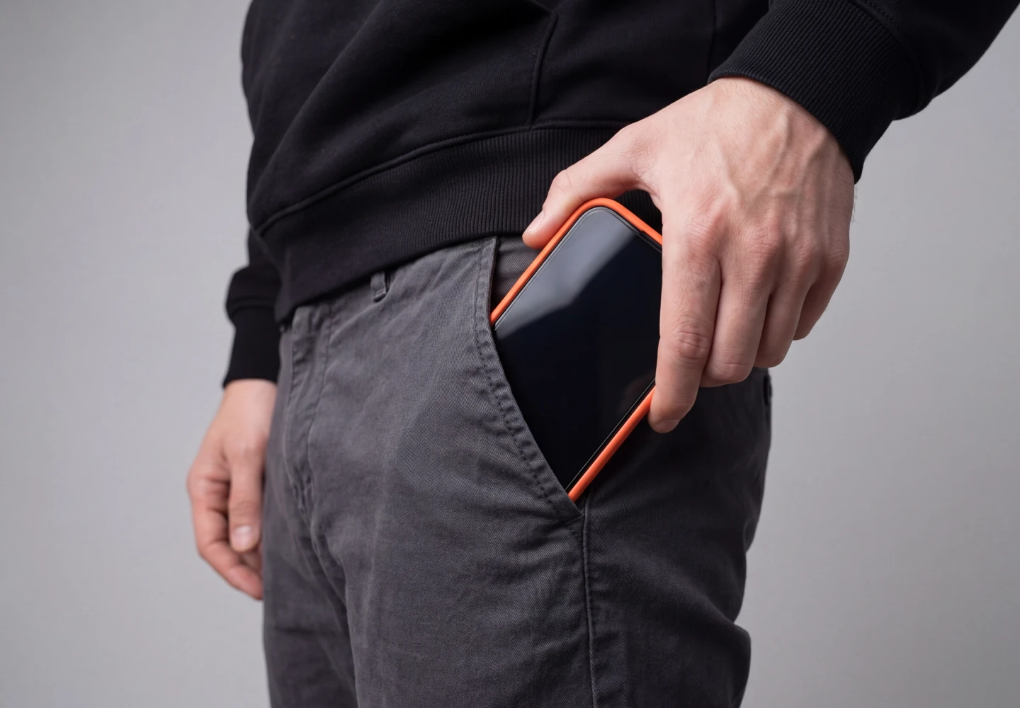 Mężczyzna wkłada iPhone z prywatyzującym szkłem hartowanym Notomi 9H do kieszeni, pokazując pełne pokrycie ekranu i dopasowanie do etui.