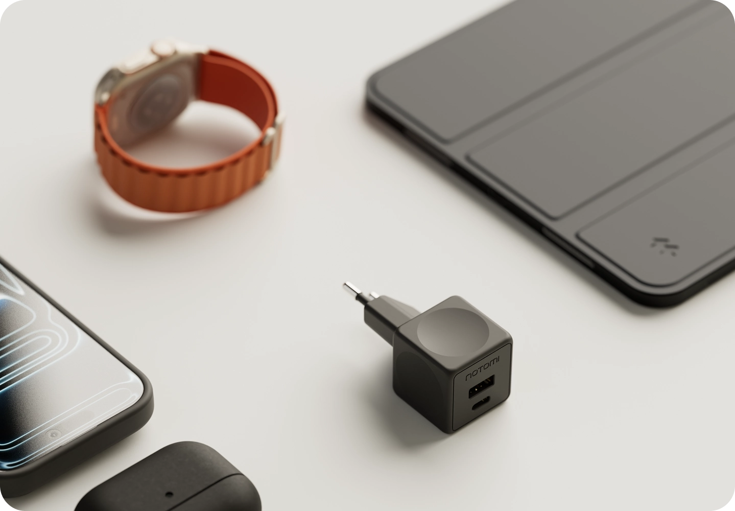 Kompaktowa ładowarka sieciowa Notomi 20 W obok telefonu, smartwatcha i tabletu.
