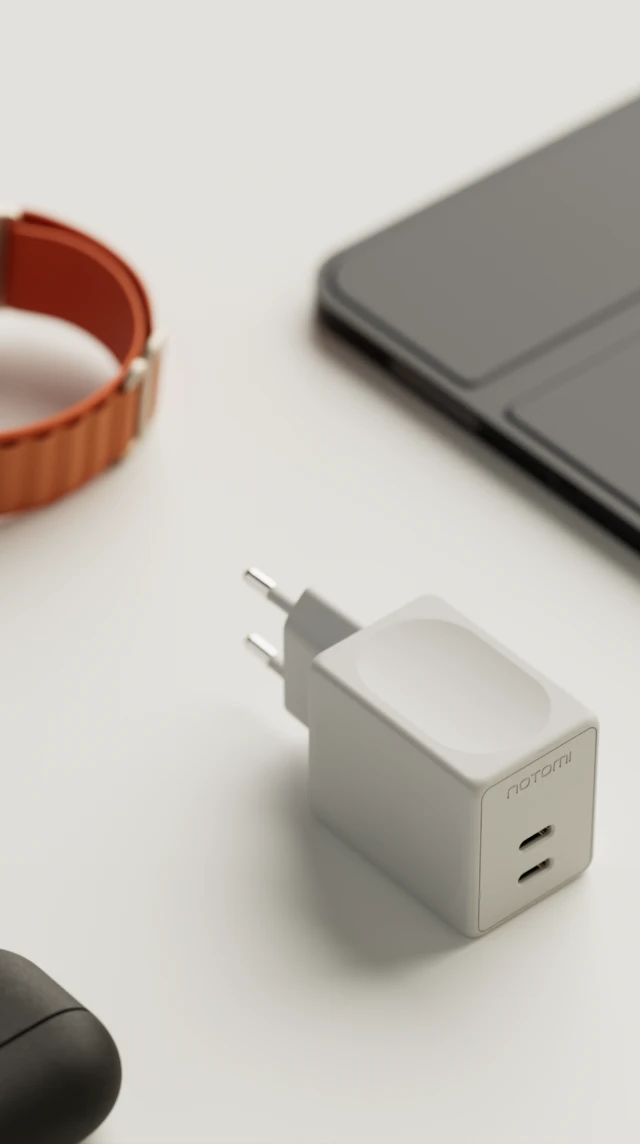 Biała, kompaktowa ładowarka sieciowa Notomi 48 W 2x USB-C ułożona na blacie obok telefonu, smartwatcha i tabletu.