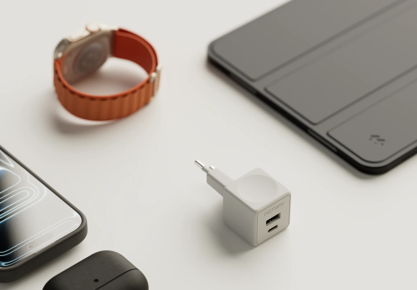 Kompaktowa ładowarka sieciowa Notomi 20 W obok telefonu, smartwatcha i tabletu.