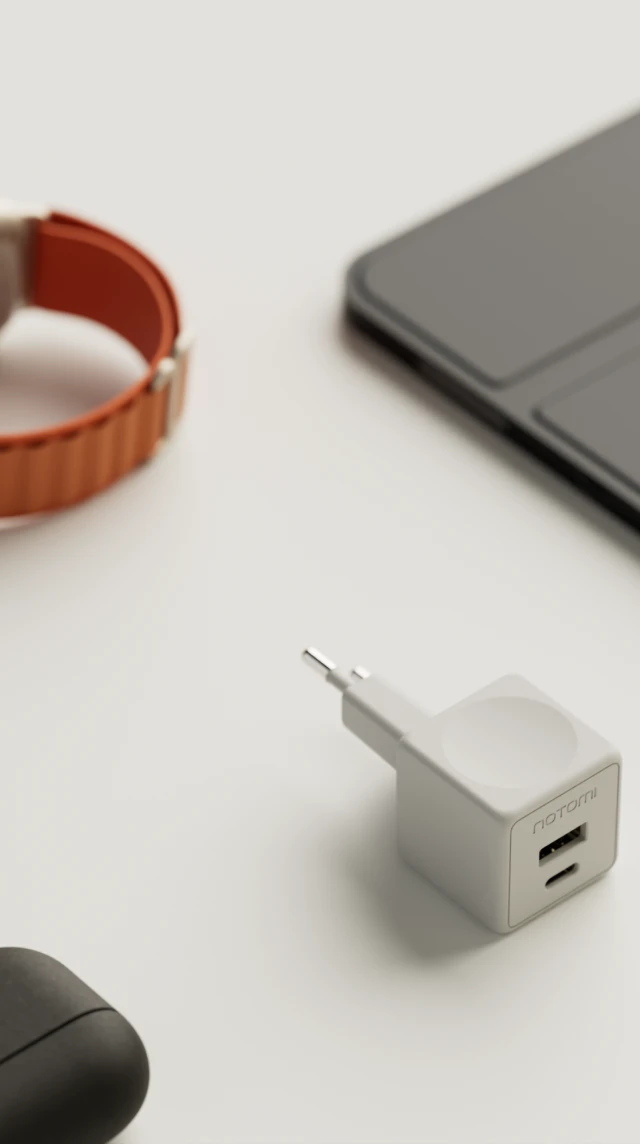 Kompaktowa ładowarka sieciowa Notomi 20 W obok telefonu, smartwatcha i tabletu.