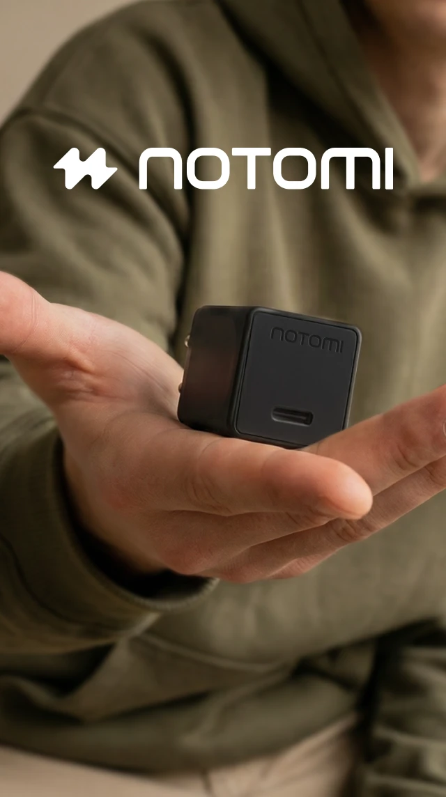Kompaktowa czarna ładowarka sieciowa Notomi 25 W USB-C trzymana w dłoni.