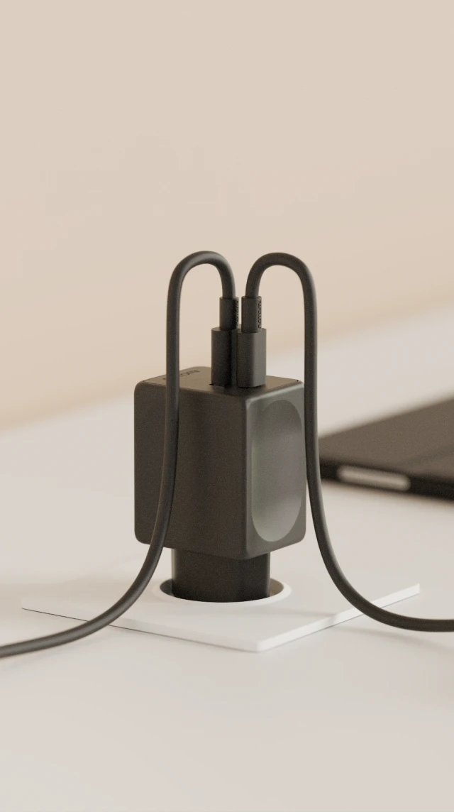 Czarna ładowarka sieciowa Notomi 48 W z dwoma podłączonymi przewodami USB-C - ładuje jednocześnie smartfona i słuchawki.